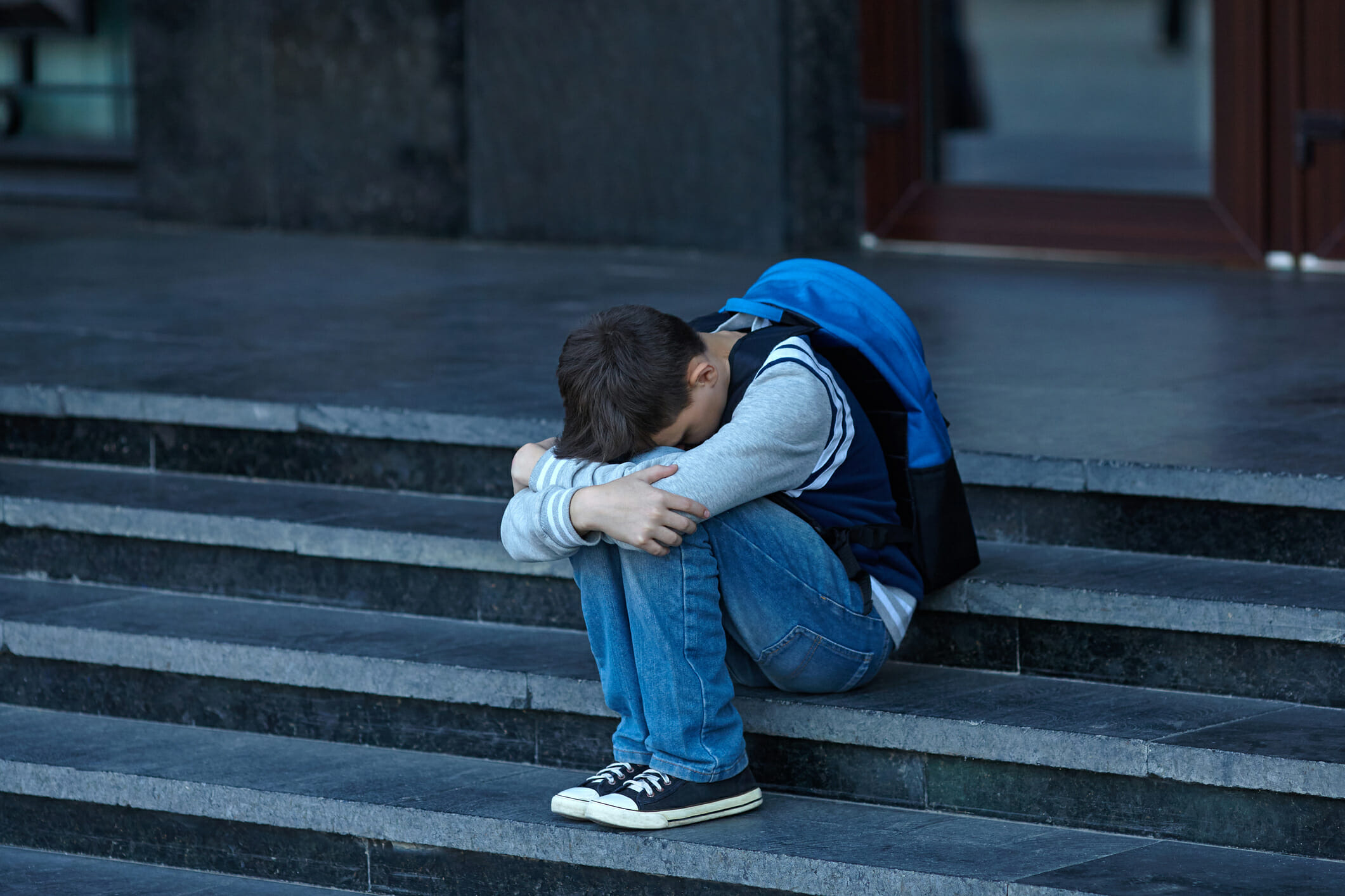 Schoolboy crying in the yard of the school