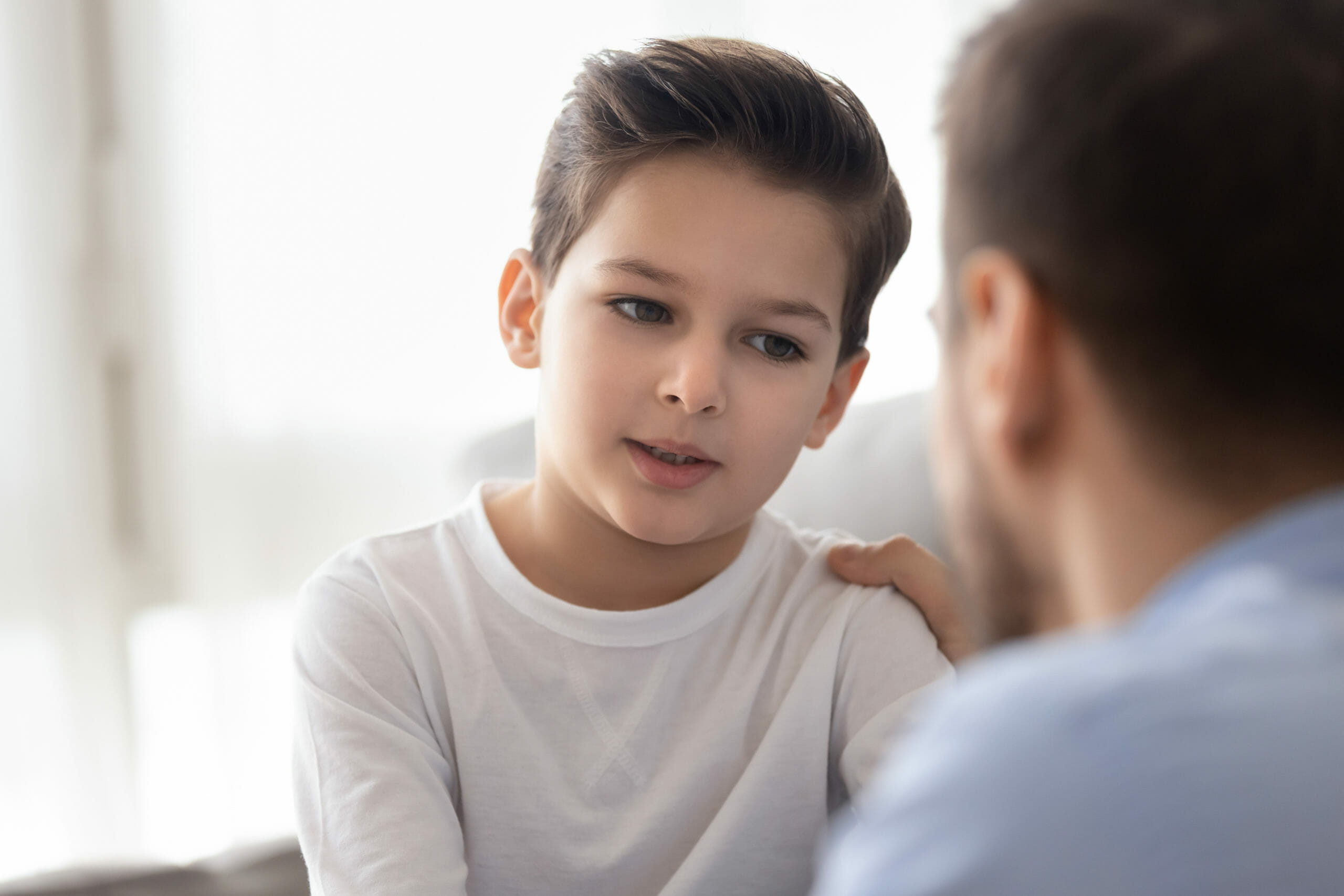 Caring dad talking with little son showing love and support